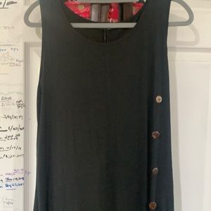 one shoulder strap w/ white buttons on the left by the waist.